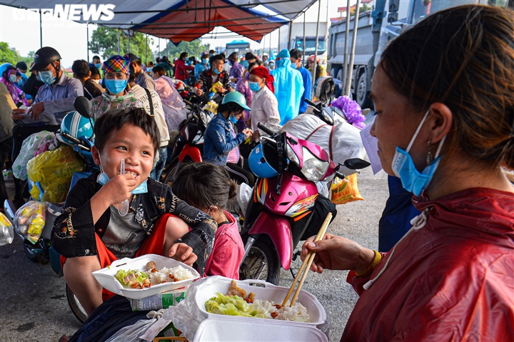 Ảnh: 500 người hồi hương ngồi bên lề đường Hà Nội ăn vội suất cơm tiếp tế  - 8