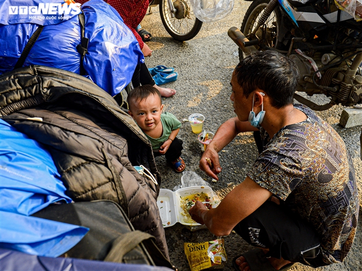 Ảnh: 500 người hồi hương ngồi bên lề đường Hà Nội ăn vội suất cơm tiếp tế - 10
