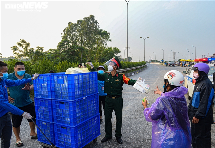 Ảnh: 500 người hồi hương ngồi bên lề đường Hà Nội ăn vội suất cơm tiếp tế  - 6