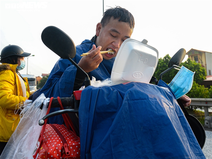 Ảnh: 500 người hồi hương ngồi bên lề đường Hà Nội ăn vội suất cơm tiếp tế  - 11