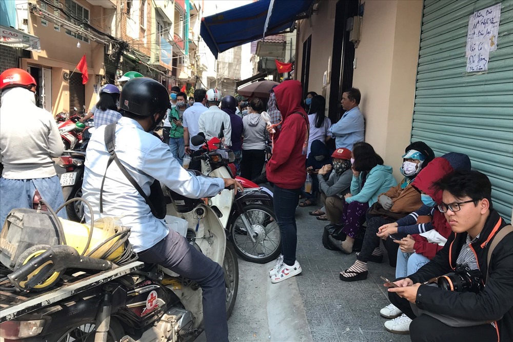 Nhiều người ngồi đợi đến giờ mua khẩu trang tại một cửa hàng trên đường Nguyễn Giản Thanh, quận 10, TPHCM. Ảnh: Anh Nhàn