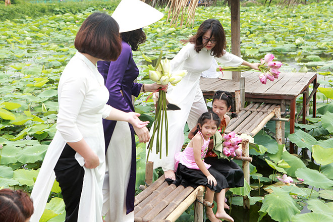 chi em dua nhau khoe lung tran non na ben hoa sen mua ha