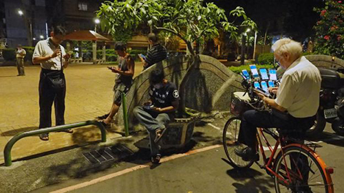 nguoi dan ong dai loan gan 11 dien thoai tren xe dap de bat pokemon