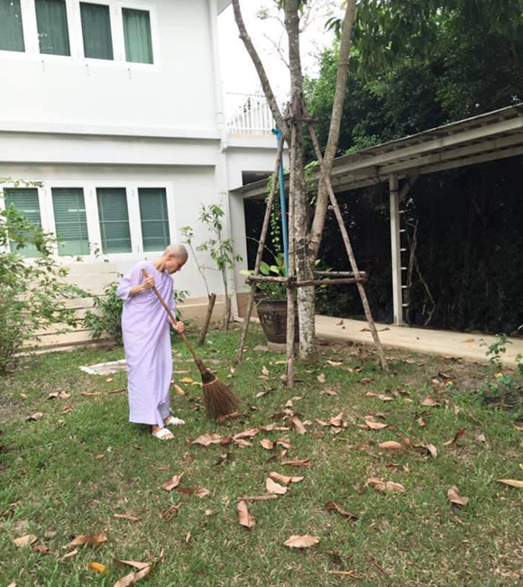 Bà Srirasmi Suwadee mặc áo ni cô quét dọn trong khuôn viên chùa. Ảnh: Twitter.