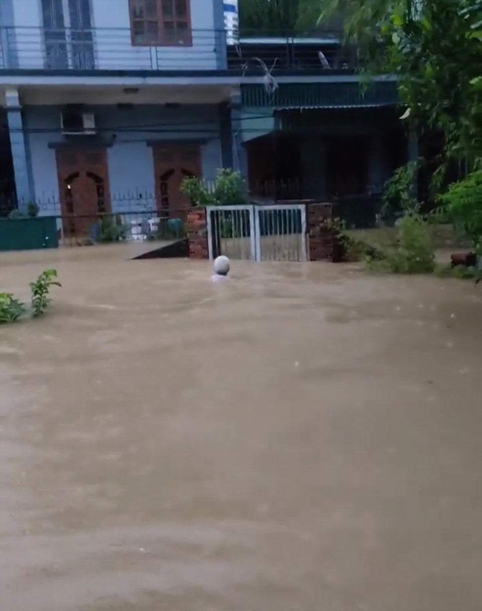 Một người đàn ông bơi vào nhà mình ở phường Hà Lầm sáng nay (17.8). Ảnh: Nguyễn Hùng
