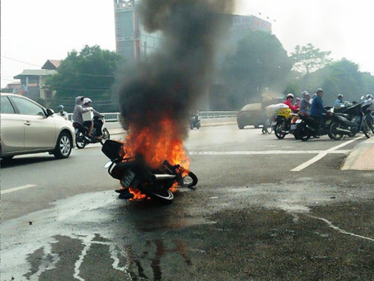 nguoi phu nu om chau thao chay khoi xe may chay ngun ngut giua pho